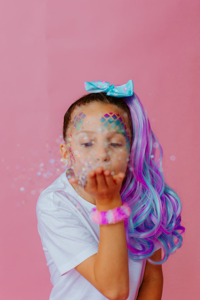 girl blow while styling her hairs with Mermaid Curled Ponytail